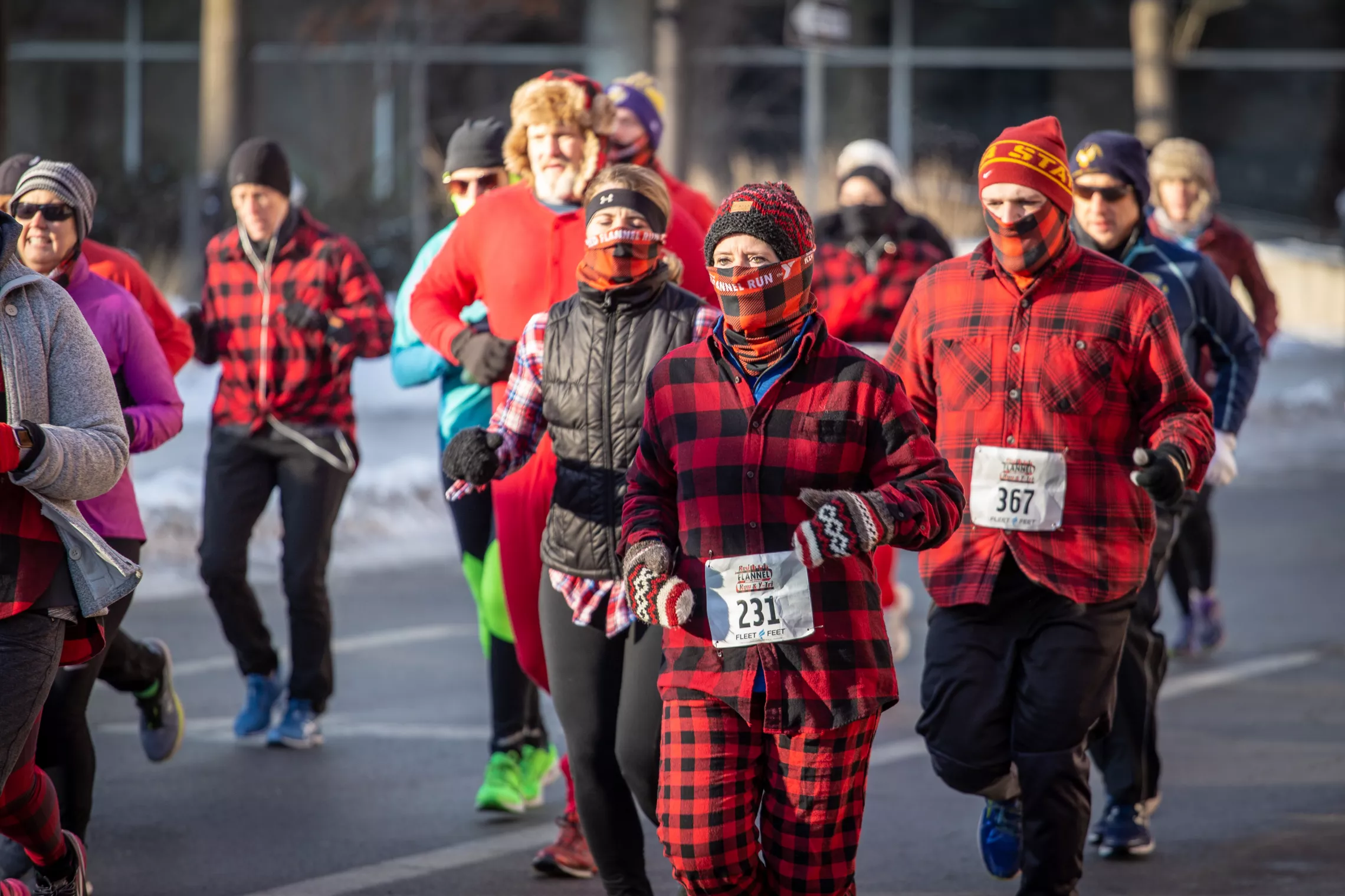 group of people decked out in flannel run in a street