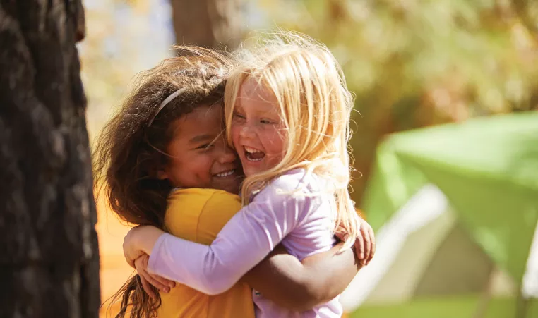 two young girls hugging and smiling