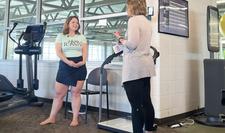 Megan Reuther from Hello Iowa trying out the secaTRU machine with Waukee Family YMCA Healthy Living Director Jackie Rayburn.